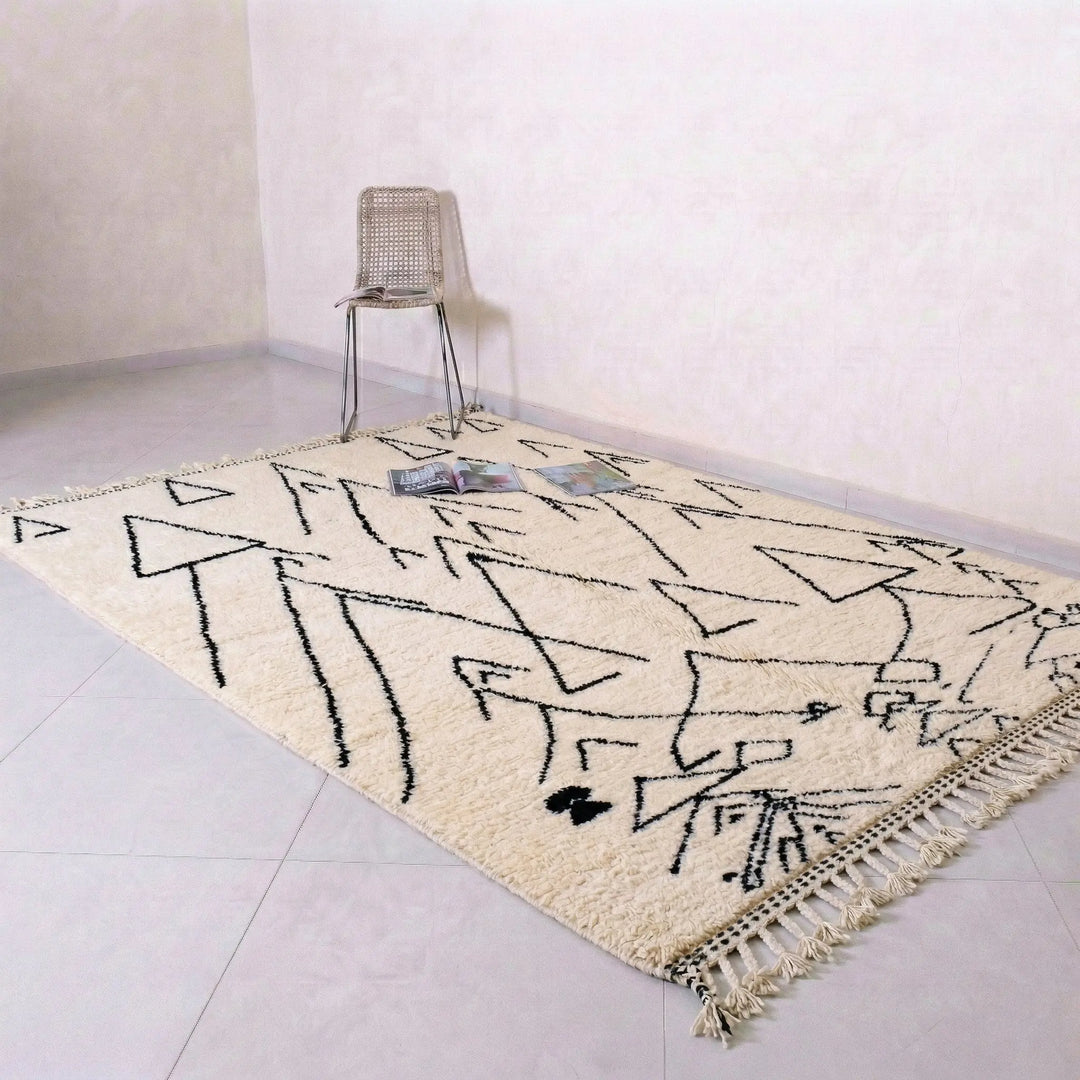 Beige rug with black geometric pattern on a light gray floor.