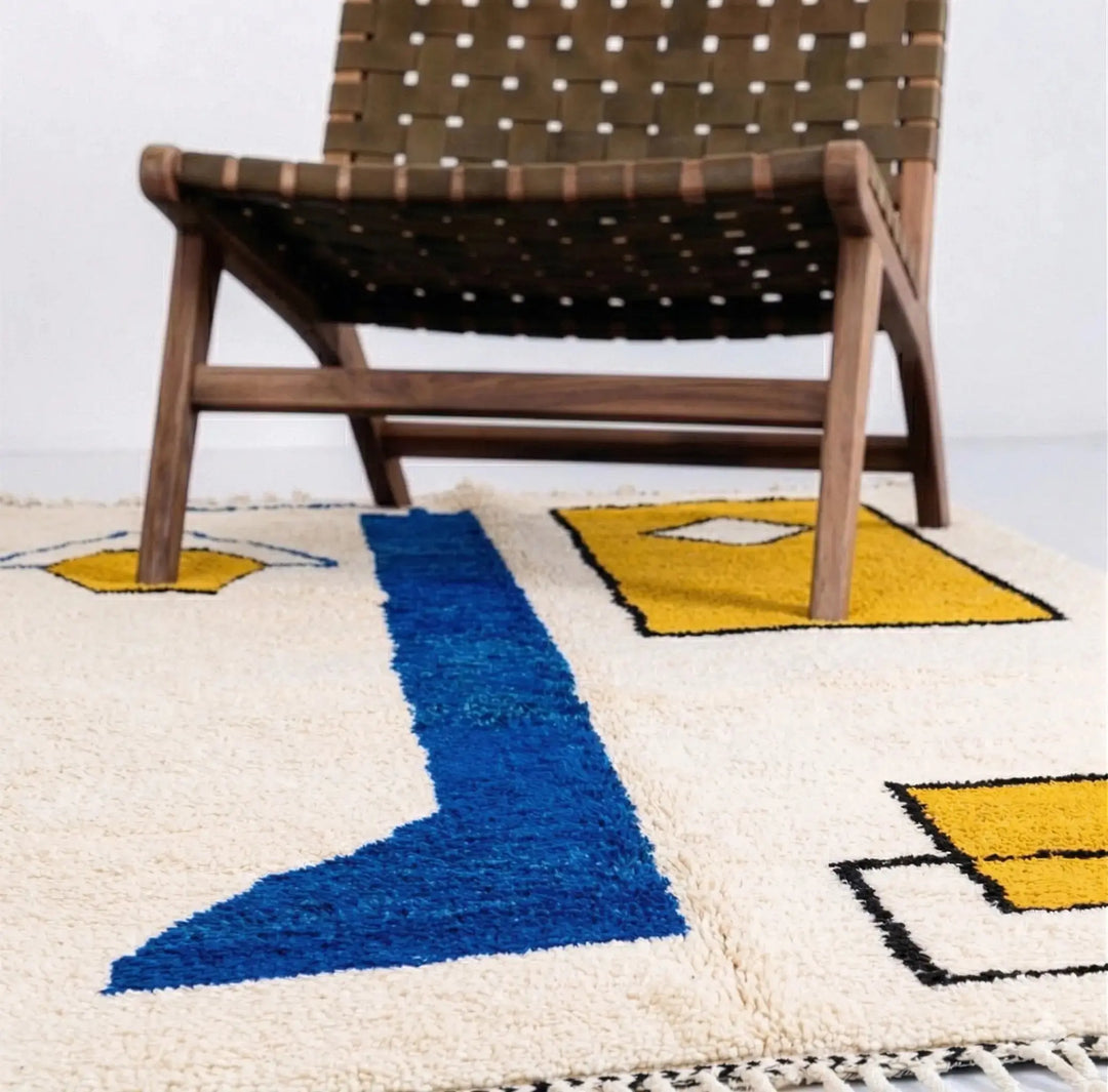 Woven chair on a geometric-patterned rug with blue and yellow shapes.