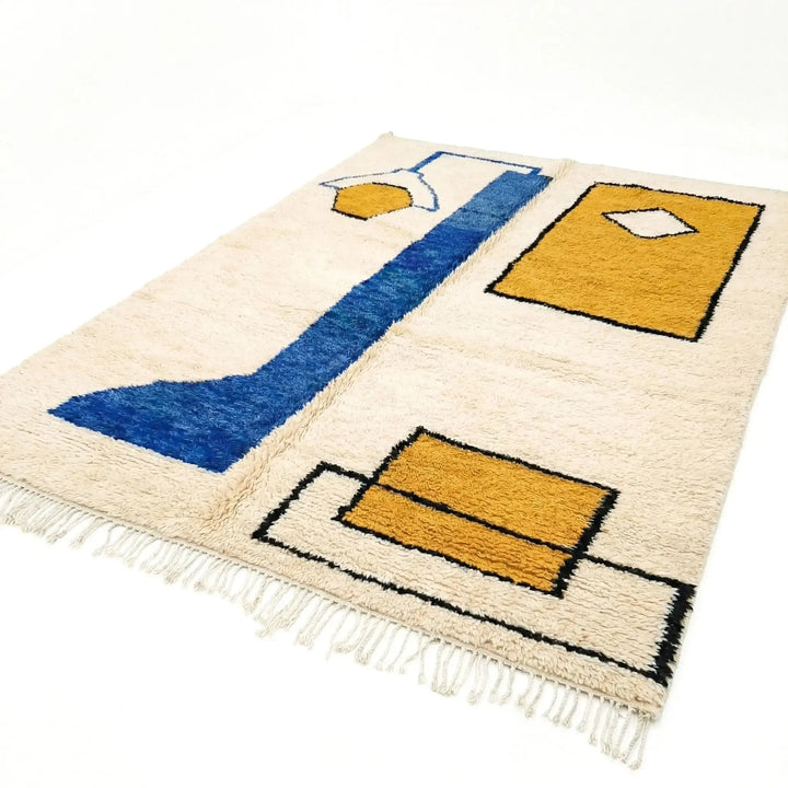 Rug with geometric design featuring blue and yellow shapes on a white background