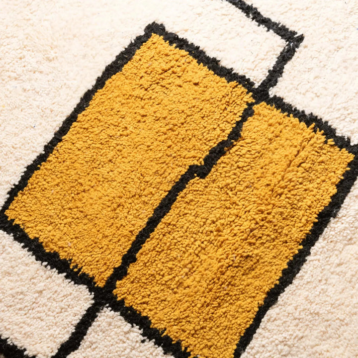 Close-up of a textured yellow rug with black lines on a beige background
