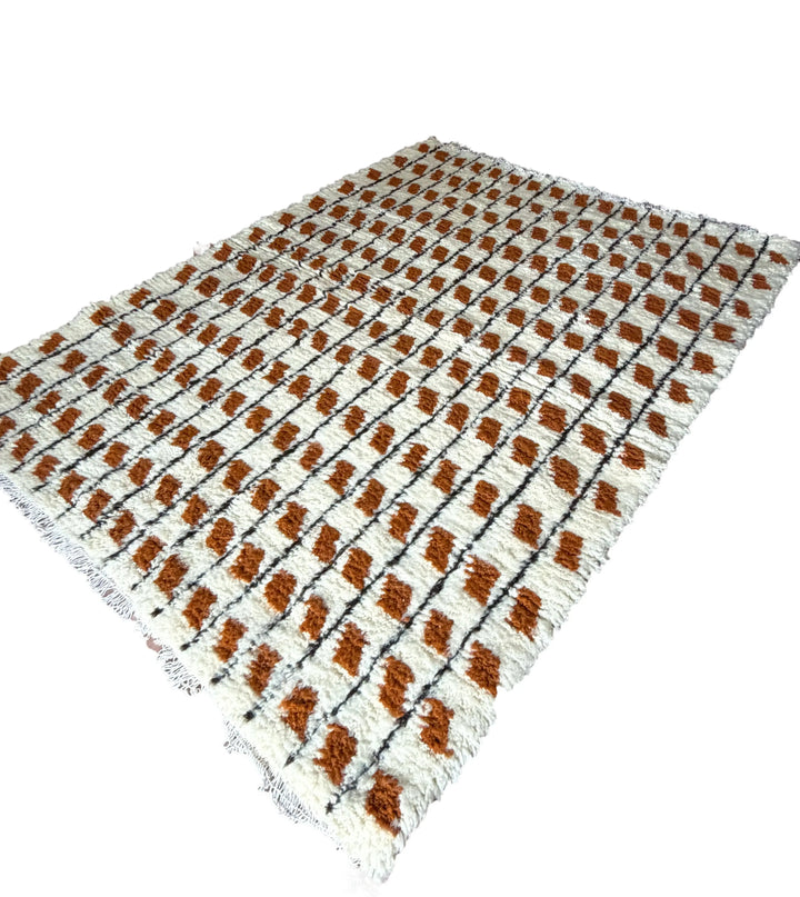 Rectangular area rug with brown and beige diamond pattern on a white background