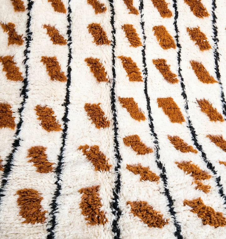 Close-up of a textured fabric with brown and black pattern on a white background