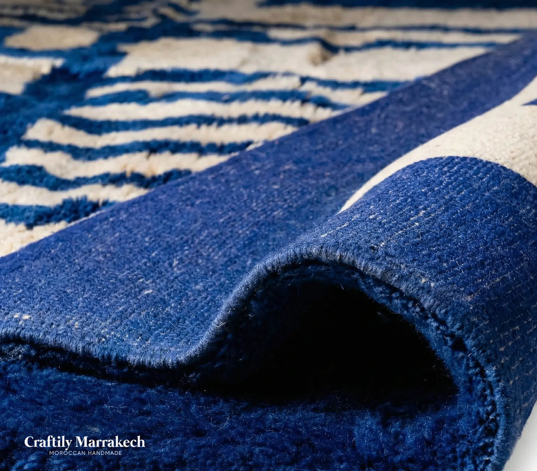 Modern boho style area rug in electric blue and ivory. Custom Beni Mrirt wool carpet hanging on display, perfect for contemporary living rooms.