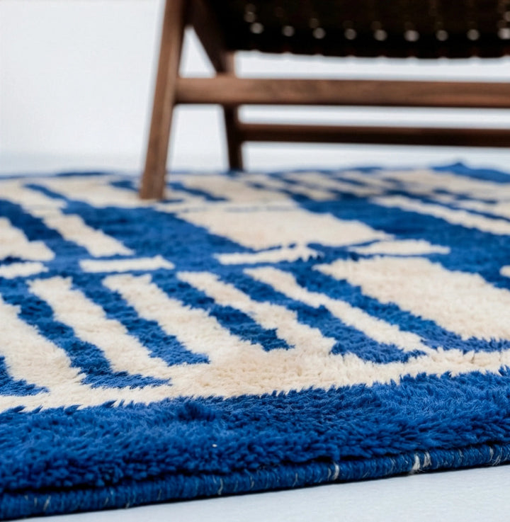 Full view of custom Beni Mrirt rug hanging, featuring bold Majorelle blue and cream abstract geometric design. Hand-knotted Middle Atlas wool carpet by Craftily Marrakech.