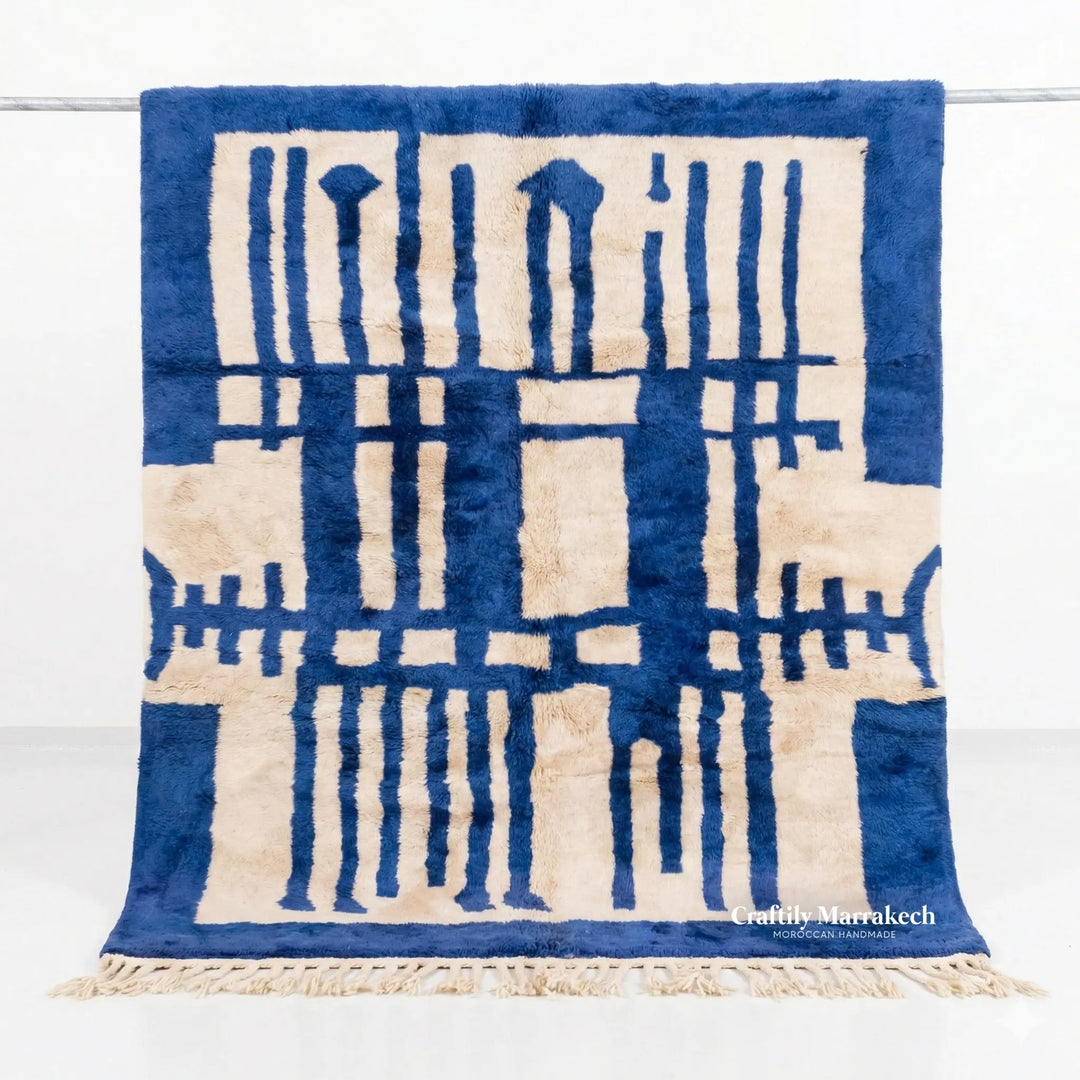 Full view of custom Beni Mrirt rug hanging, featuring bold Majorelle blue and cream abstract geometric design. Hand-knotted Middle Atlas wool carpet by Craftily Marrakech.