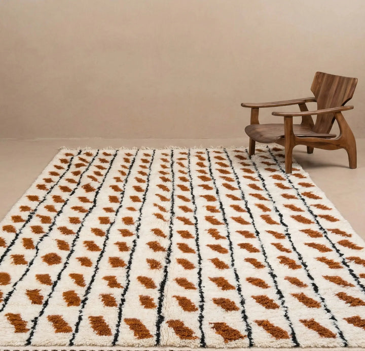 Patterned rug with brown and black design on a beige floor with a wooden chair.